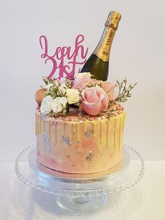 a birthday cake decorated with flowers and a bottle of champagne