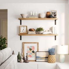 a living room with two open shelves and pictures on the wall, one shelf is filled with vases