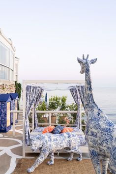 two giraffes are standing next to a bed