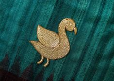 a close up of a piece of cloth with a gold embroidered duck on the side