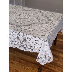 the table cloth is white and has an intricate design on it, along with a lace edge