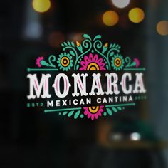 the logo for an mexican restaurant is seen through a glass door with boket lights in the background