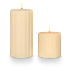 two white candles sitting next to each other