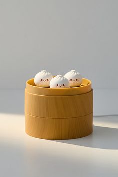 three little white eggs sitting in a wooden container