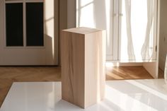 a wooden block sitting on top of a white table in front of a closet door