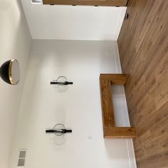 an overhead view of a bathroom with wood flooring and white walls in the background