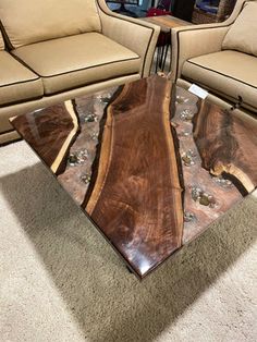 a coffee table made out of wood and glass in the middle of a living room