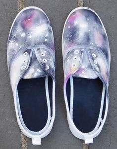 a pair of white shoes with space painted on them