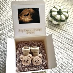 an open box with two baby shoes in it