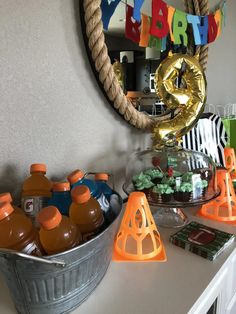 a birthday party with orange and blue items on the table, including an orange cone