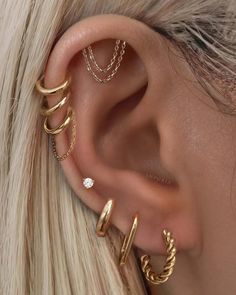 a woman with blonde hair wearing three different ear piercings