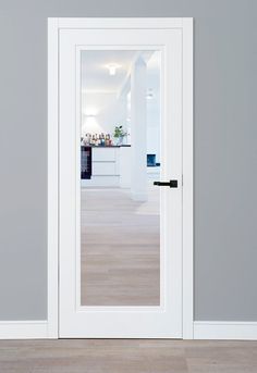 an open white door in a room with grey walls and wood flooring on the side