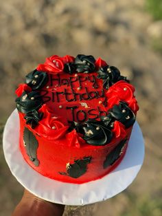 a red and black birthday cake on a white plate