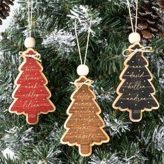 three wooden ornaments hanging from a christmas tree