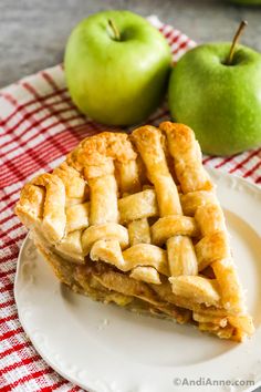 a piece of pie on a plate next to an apple