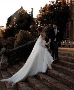 a bride and groom walking down some steps