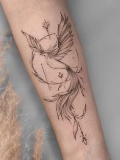 a woman's arm with a bird tattoo on it