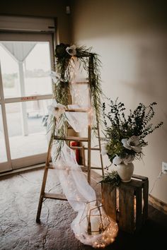 a ladder is decorated with greenery and lights