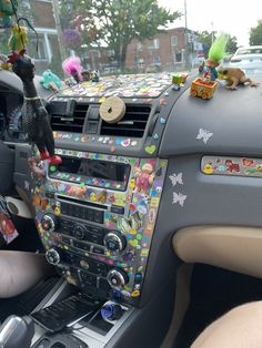 the interior of a car decorated with many stickers and decorations on it's dash board