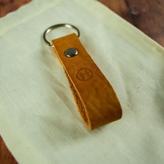 a wooden keychain sitting on top of a white cloth