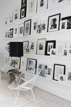 a living room with white walls and pictures on the wall