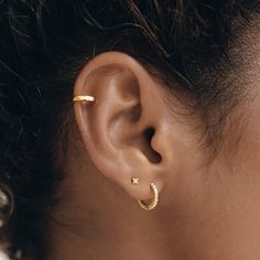 a woman's ear is shown with two small stars on the side of it