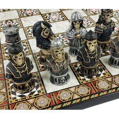 a close up of a chess board with knights on it and skulls in the middle