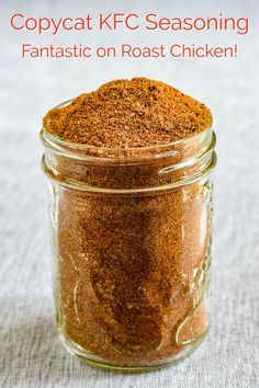 a glass jar filled with red seasoning sitting on top of a table