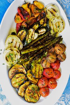 grilled vegetables arranged in a white bowl on a blue and white tablecloth,