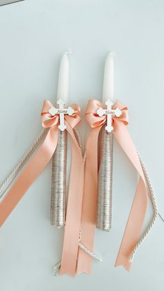 two candles with bows on them are sitting next to each other and tied together in twine