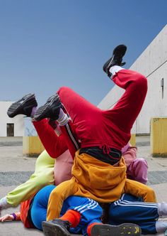 three people are sitting on the ground with their feet in the air and one is upside down