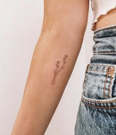 a woman's arm with a single flower tattoo on the left side of her arm