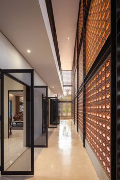 the hallway is lined with glass bottles on the wall and doors leading to another room