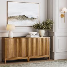 a living room scene with focus on the sideboard and vases in front of it