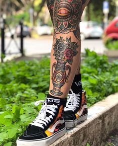 a person with tattoos standing on a ledge