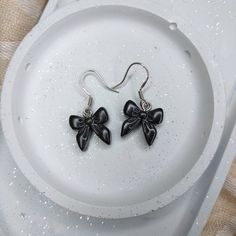 These handmade small black bow earrings will be a wonderful gift for a girl. These adorable bows are perfect for any holiday season. The earrings are lightweight and completely non-allergenic * Handmade bow drop earrings. * Made from polymer clay. * Bow length 1.5 cm. * Material of stands: stainless steel. * The earrings are light and comfortable to wear. * The earrings will be delivered in a beautifully packaged box. The set includes 1 pair of silicone pads. Please keep in mind that all of my jewelry is handmade and you will receive a unique piece. Size and color will be as close as possible to those shown in the photo, but slight differences in appearance may occur. Black Bow Earrings, Small Black Earrings, Bow Jewelry, Bow Earrings, Cute Bow, Handmade Bows, Fashion Elegant, Black Earrings, Cute Bows