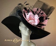 Looks elegant and beautiful from all angles.  Pretty pink floral with loads of fluttering black feathers. Teamed with delicious layers of tulle, netting, and crinoline. Customization is available; please inquire to see if we can meet your needs. Perfect for Kentucky Derby, Del Mar Races, Melbourne Cup, Royal Ascot, Breeders' Cup, Hat Contests, Church, Gala, Derby, Cocktail, High Tea, Weddings, Preakness, and more.   *FREE SHIPPING  Though often copied by hobbyists and even high-end department stores, discriminating fashionistas from all walks of life count on Aimee's pieces to lead the trends and make one-of-a-kind statements in their ensembles, fashion shoots, and style shows. You can also see her designs on everyone from judges to Real Housewives; from news anchors to Hollywood stylists; Croquis, Fancy Hats Classy, 50s Hats, Cup Hat, Elegant Hat, Easter Hat, Royal Ascot Hats, Breeders Cup, Black Church