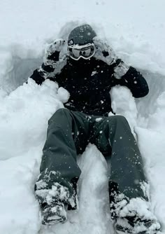 a person sitting in the snow with their feet up and his face covered by snow