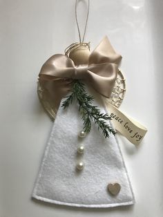 a christmas tree ornament hanging on a white plate with a ribbon and tag