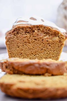 a loaf of bread sitting on top of a white plate next to a piece of cake