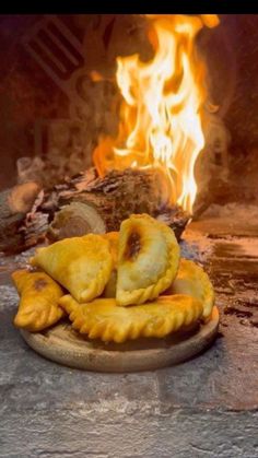 some food is sitting on a plate in front of a fire and it looks like they are coming out of the oven