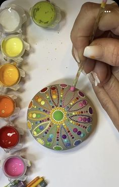 a person is painting on a plate with paint