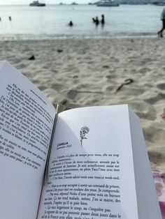 an open book sitting on top of a beach