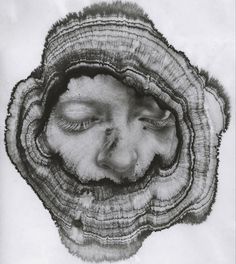 a black and white photo of a woman's face in the center of a piece of wood