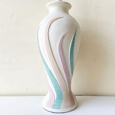 a white vase sitting on top of a table