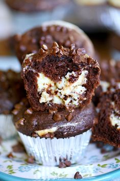 chocolate cupcakes with white frosting and chopped nuts on a blue floral plate