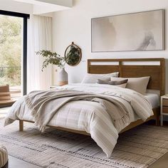 a bedroom with a large bed and two chairs in front of a window that looks out onto the outdoors