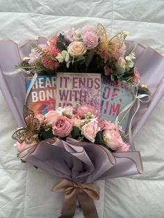 a bouquet of pink flowers on top of a white sheet with a sign that reads, i love you