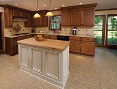 a large kitchen with wooden cabinets and an island in front of the stove top oven