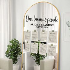 a mirror with seating cards on it and a potted plant next to it in front of the mirror